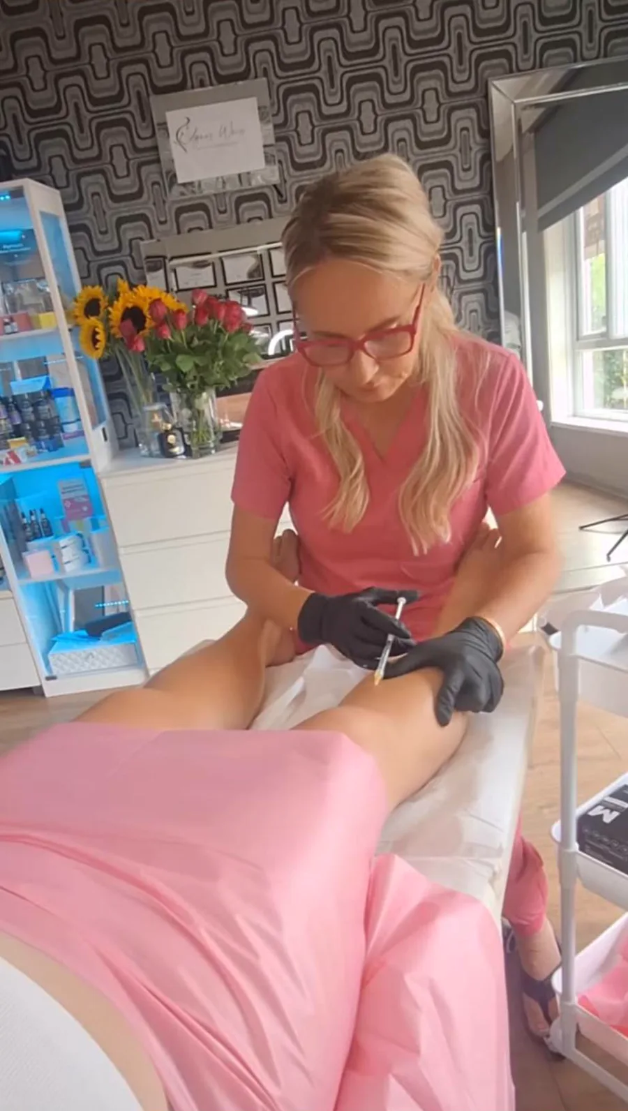 Agnes w różowym uniformie wykonuje iniekcję